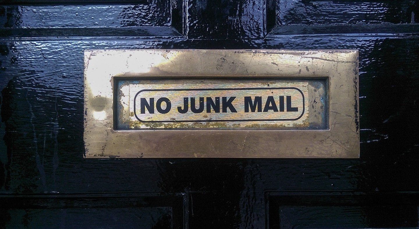 Bilde av en postboks i en dør med teksten "No junk mail"